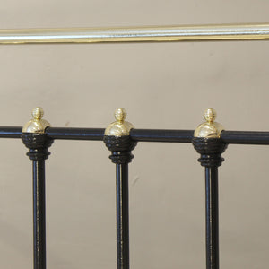 Decorative metal railing with black posts and gold finials on a beige background