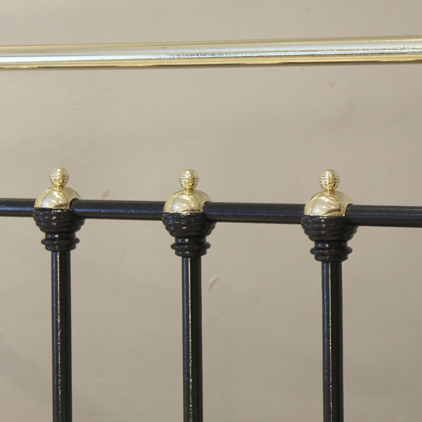 Decorative metal railing with black posts and gold finials on a beige background