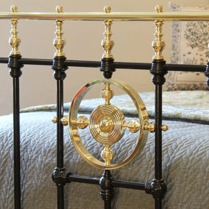 Close-up of a decorative metal bed frame with gold accents.