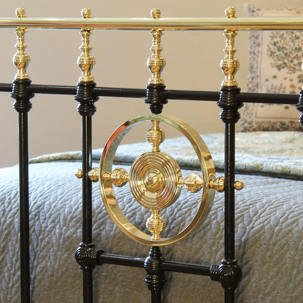 Close-up of a decorative metal bed frame with gold accents.