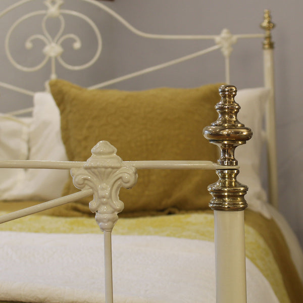 Close-up of a decorative metal bed frame with ornate design and gold accents.