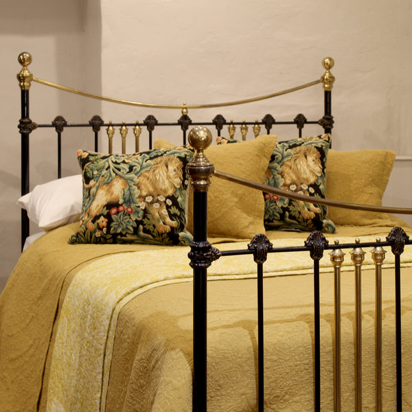 Decorative bed with gold bedding and lion-themed pillows in a bedroom setting.