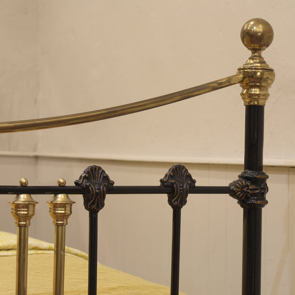 Close-up of a decorative metal antique bed frame with gold and black details.