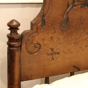 Close-up of an ornate wooden headboard with intricate carvings.