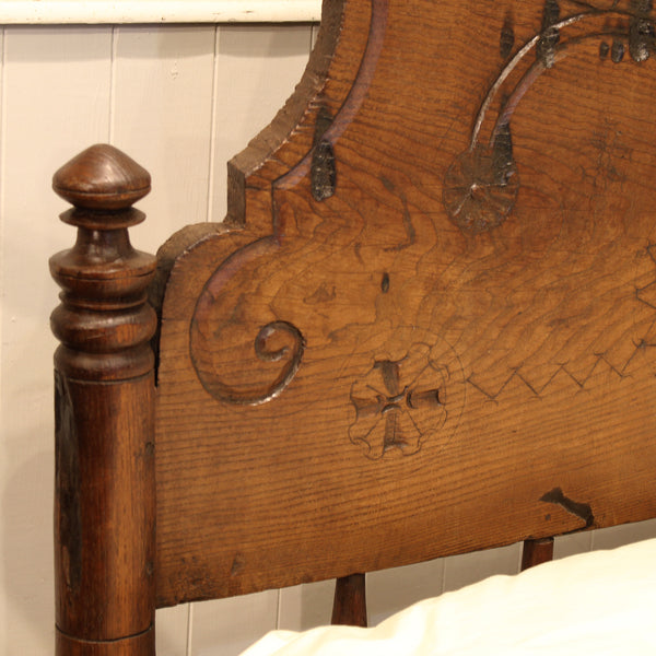 Close-up of an ornate wooden headboard with intricate carvings.